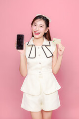 Pretty Asian woman model long hair perfect clear fresh skin smile on isolated pink background....