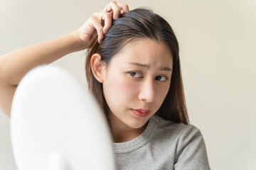 Fototapeta premium Young woman worrying about her thin hair and hair fall