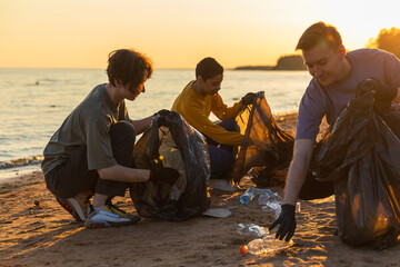 Earth day. Volunteers activists team collects garbage cleaning of beach coastal zone. Woman mans...