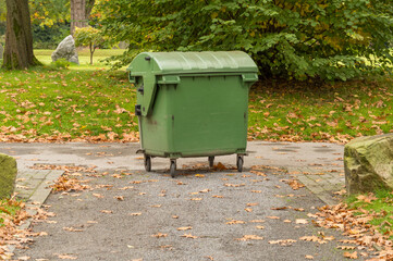 Green rolling garbage can on the footpath