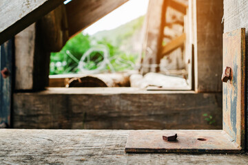The ancient railway piers and large beams made of wood support an old rundown train bridge and were constructed during World War II.  View of old wooden bridge of train railway along cliffs and rivers