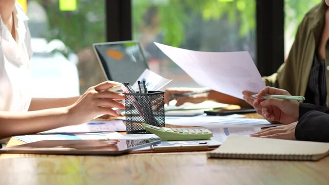 Collaborative workspace showcasing teamwork and productivity, with hands engaged in discussion over documents and tools on table, enhancing office collaboration and effective meetings.