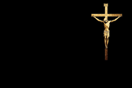 A golden crucifix depicting Jesus Christ on the cross against a black background. The cross is ornate, with a simple yet elegant design, emphasizing the figure of Christ.
