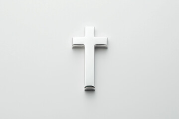 Obraz premium A shiny silver cross on a plain white background, symbolizing faith and spirituality.