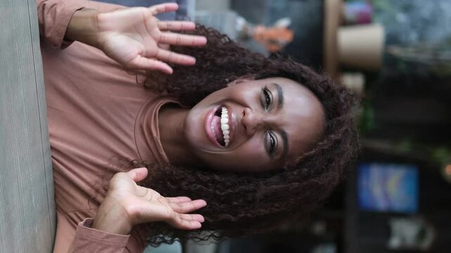 A beautiful young female blogger communicates through an online video call with subscribers recording stories for social networks. Happy African American woman talking on video call