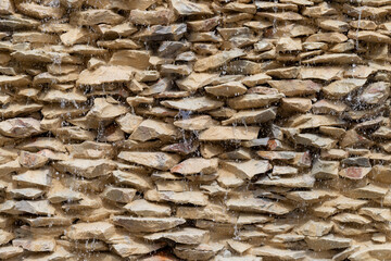 Water drops flowing down the stone wall, old stones, architectural, texture abstract background