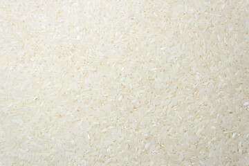 Dry Uncooked White Rice Background - Top View, Flat Lay. Scattered Raw Long Grain Rice. Asian Cuisine and Culture. Healthy Eating Ingredients. Diet Food