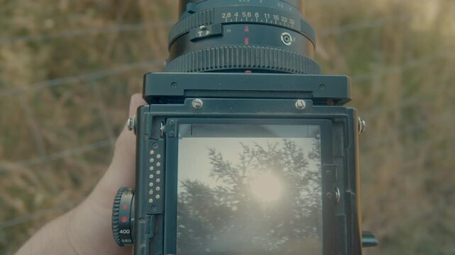 Overhead view of the viewfinder of a classic camera filming a countryside landscape at the daytime