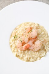 Delicious risotto with shrimps and cheese on plate, top view