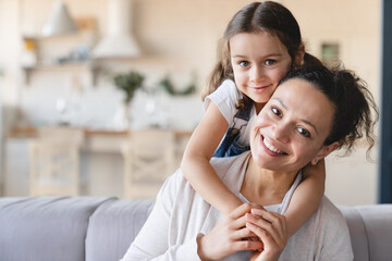 Happy caucasian mother and cute little daughter girl hugging embracing , spending time together...