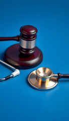 Healthcare legislation and regulation, medical malpractice decision and health care injury personal attorney concept with gavel and stethoscope isolated on blue background with copy space isolated w