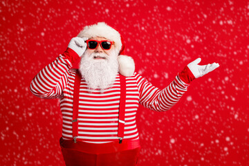 Portrait of his he nice attractive handsome cheerful cheery Santa demonstrating copy space gift present surprise bargain offer isolated on bright vivid shine vibrant red color background