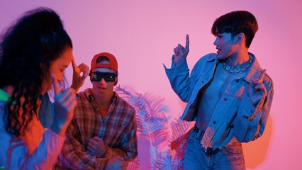 Hispanic hipster wear colorful cloth and waving to freestyle music. Professional break dancer moving to lively beat with neon light and led light with modern studio surrounded by friend. Regalement.