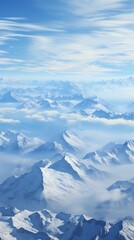 Fototapeta premium Breathtaking aerial view of snow-capped mountains beneath a serene blue sky, creating a tranquil and awe-inspiring natural landscape.