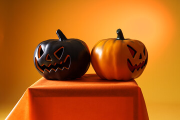 citrouille noire et citrouille orange pour halloween sur fond orange