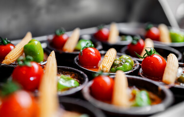 Baked potato gratin topped with tomato, paprika and corn.