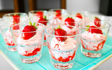 Glasses of whipped cream with strawberries.