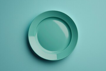 A single, green, round dinner plate on a blue background