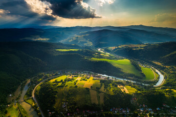 Promienie słońca nad g&oacute;rami i rzeką Poprad w Żegiestowie.
