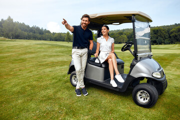 A couple enjoys a delightful joyride on a golf cart set against a beautiful and scenic landscape