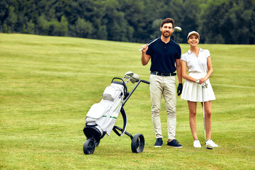 Obraz premium A Loving Couple Enjoying a Leisurely Stroll with Their Baby Stroller in a Lush Green Field