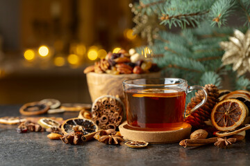 Tea with spices and dry fruits on a kitchen table.