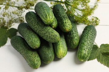 Fresh green cucumbers and spices on white wooden table