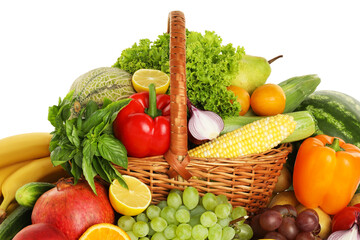 Different fresh fruits and vegetables in wicker basket isolated on white