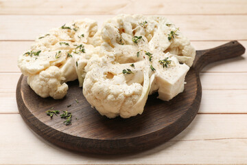 Uncooked cauliflower steaks with spices on wooden table, closeup