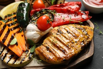 Delicious grilled vegetables and chicken breast on table, closeup