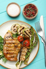 Delicious grilled vegetables and chicken breast on light blue wooden table, flat lay