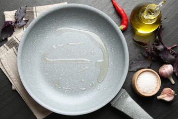 Frying pan with cooking oil and products on dark textured table, flat lay