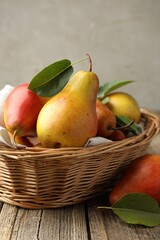 Ripe juicy pears in wicker basket on wooden table