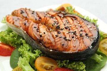 Tasty grilled salmon steak and vegetables on plate, closeup