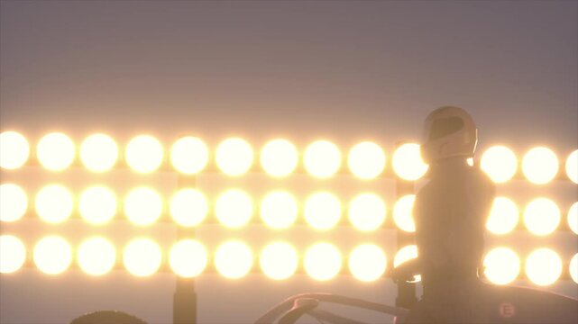 Silhouette of race car driver celebrating his victory in the race against bright lights