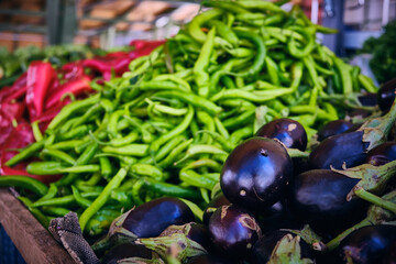 Eggplants, green and red peppers and other vegetables at farmers market
