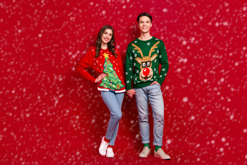 Fototapeta premium Full size photo of two idyllic lovely people standing hold arms enjoy newyear atmosphere isolated on red color background
