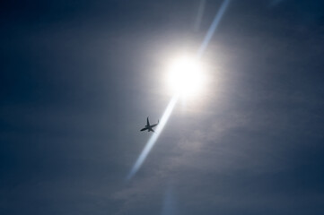 An airplane in the sky with sun