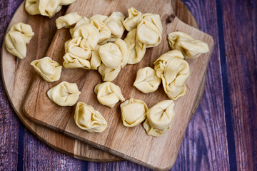 Raw fresh tortelloni pasta c Ring-shaped pasta  filled with   spinach and ricotta cheese.   Ready for cooking. Italian food concept.