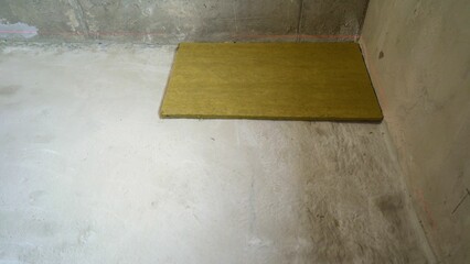 Construction worker laying down acoustic insulation panel