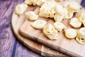 Raw fresh tortelloni pasta c Ring-shaped pasta  filled with   spinach and ricotta cheese.   Ready for cooking. Italian food concept.