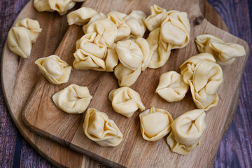 Raw fresh tortelloni pasta c Ring-shaped pasta  filled with   spinach and ricotta cheese.   Ready for cooking. Italian food concept.