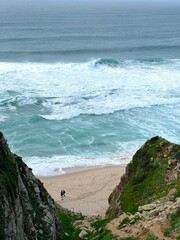 Atlantic ocean coast in Portugal. Scenic view of coastline with huge boulders at the Praia da Ursa beach near Cabo da Roca (Cape Roca). The westernmost point of mainland Europe.
