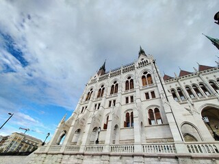 A close-up perspective of Hungary’s Parliament building, showcasing the towering neo-Gothic spires and windows of this architectural masterpiece.