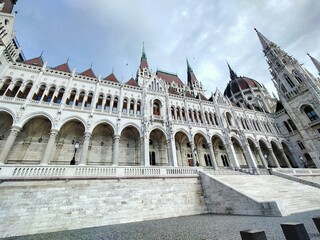 A wide view of the Hungary Parliament building, with the large central dome and ornate arches in full display. This angle highlights the building’s stunning symmetry and intricate details.