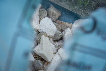 decorative garden stones, decorative white and gray stoneware for the garden in a torn bag.