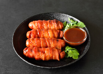 Bacon wrapped sausages with barbecue sauce