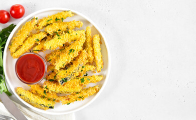 Crispy fried zucchini sticks and tomato sauce on plate