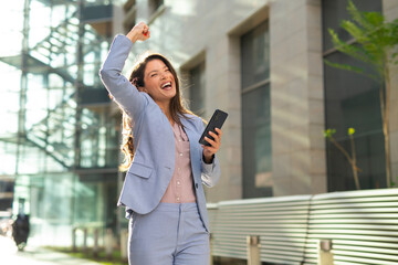 Fototapeta premium Happy businesswoman standing outdoor in front office building