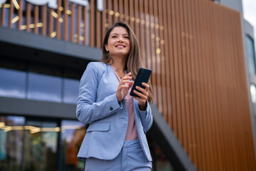 Portrait of business woman holding phone in hands
